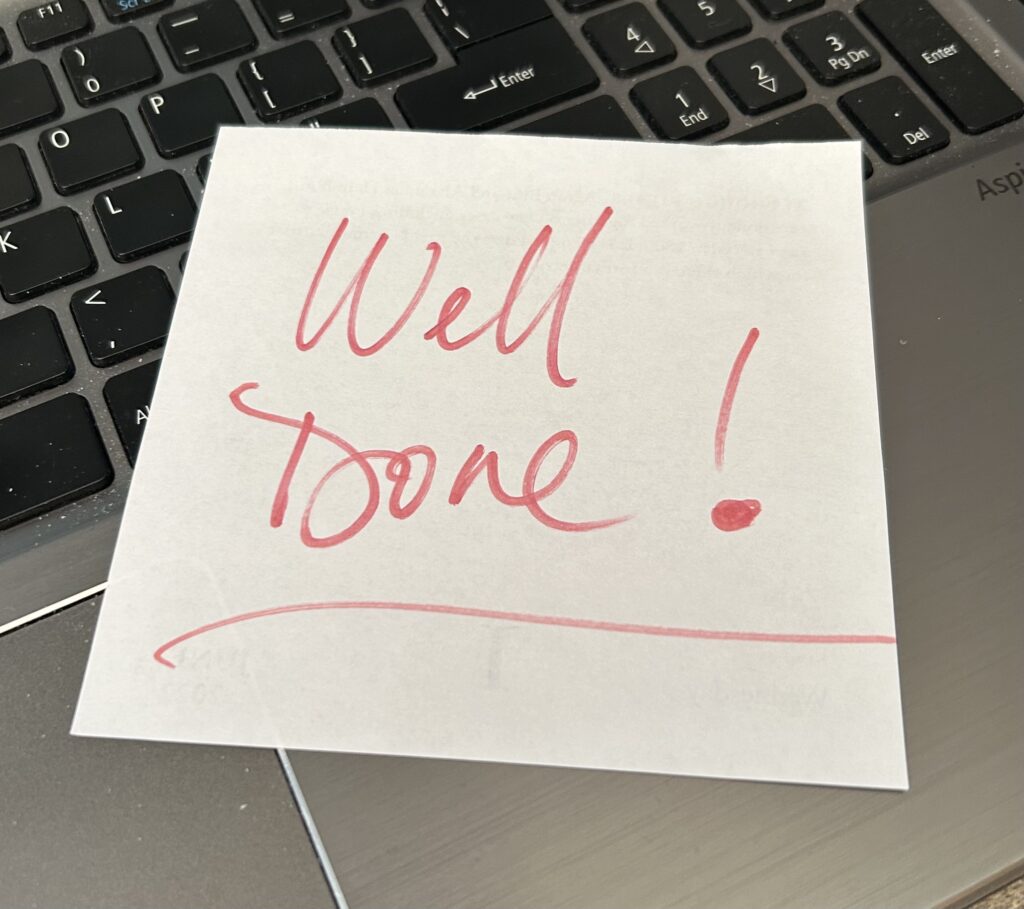 "well done" written on a piece of paper