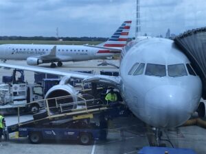 American Eagle planes at an airport gate, one being serviced. Includes text "American Eagle" and "Power Stow.